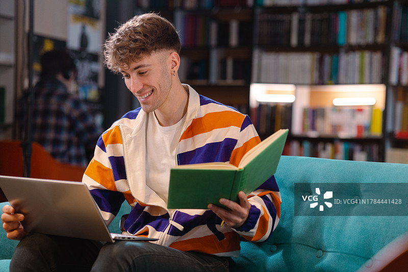 男学生使用笔记本电脑听线上课程图片素材