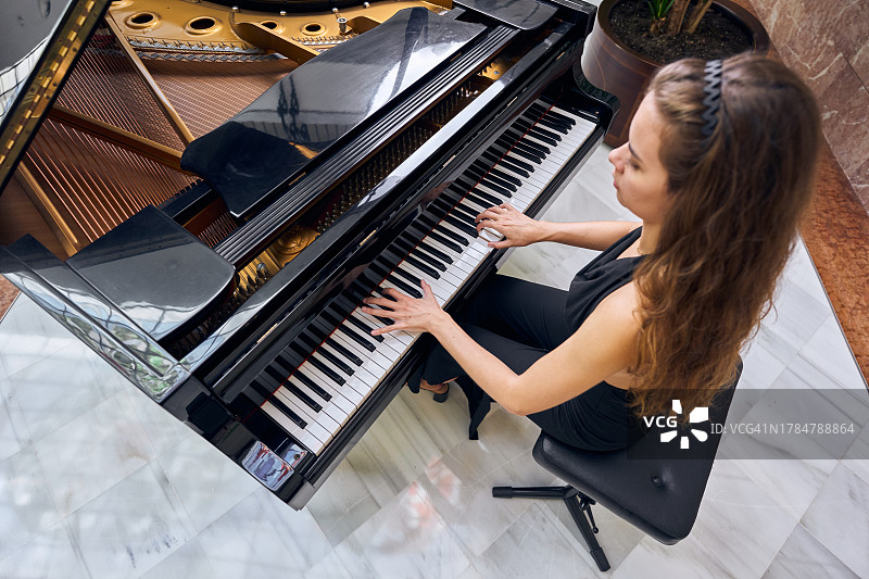 年轻女子在房间里弹钢琴图片素材