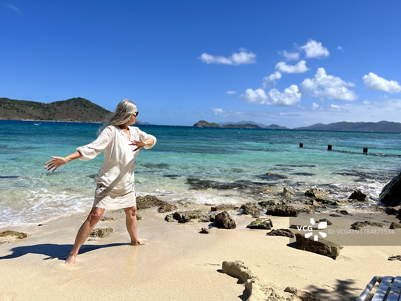 老年妇女在海滩上练习太极图片素材
