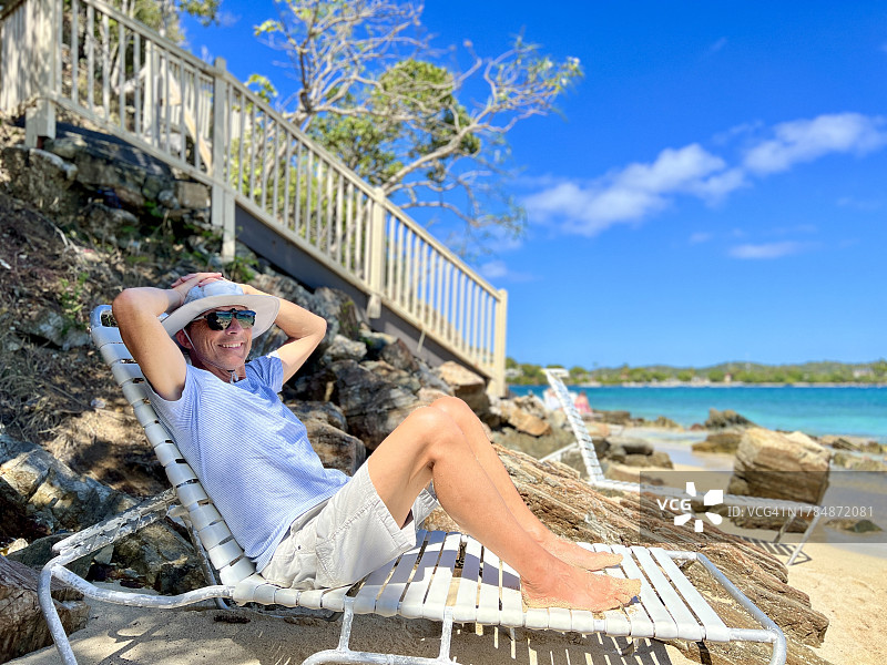 在圣托马斯岛海滩躺椅上放松微笑的老年男人图片素材