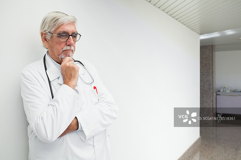 医生靠在走廊的墙上思考图片素材