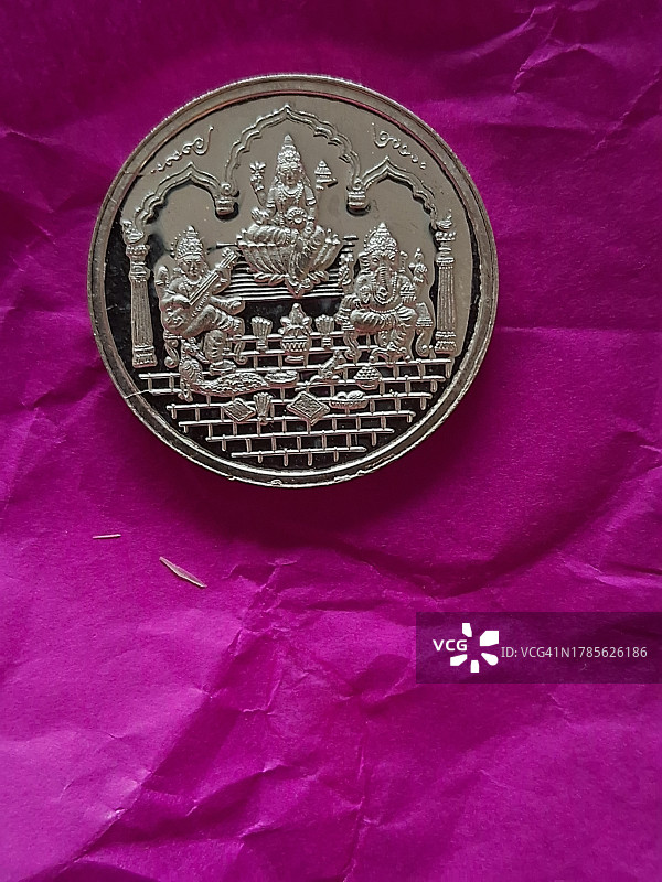 象头神/拉克希米女神/萨拉斯瓦蒂女神银币粉色纸张背景/排灯节图片素材
