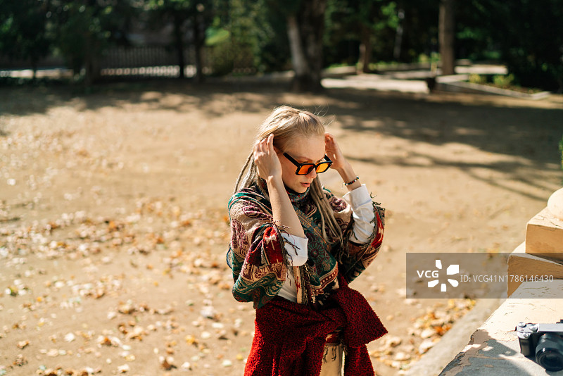 戴太阳镜的女人站在人行道上图片素材