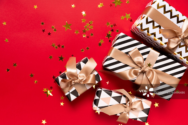 节日圣诞新年背景，红色背景上的彩色礼品盒和节日装饰品。新年礼物和圣诞礼物顶视图图片素材