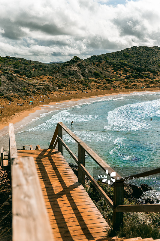 通往沙滩的木制楼梯，卡瓦列里亚海滩，西班牙梅诺卡岛图片素材