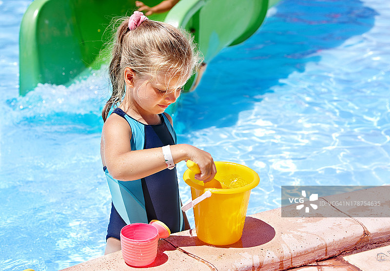 在游泳池里拿着水桶的小孩图片素材