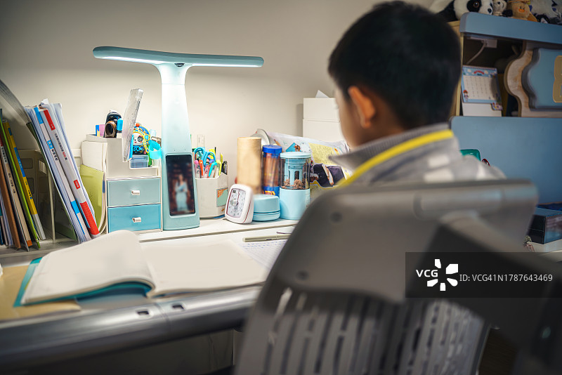 亚洲男孩与智能台灯互动图片素材