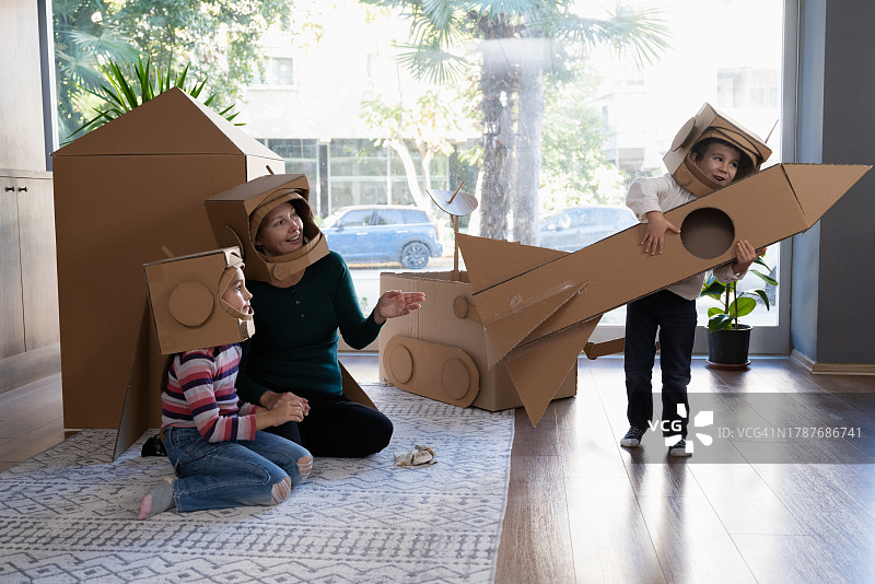 母亲、儿子和女儿玩宇航员角色扮演游戏的家庭图片素材