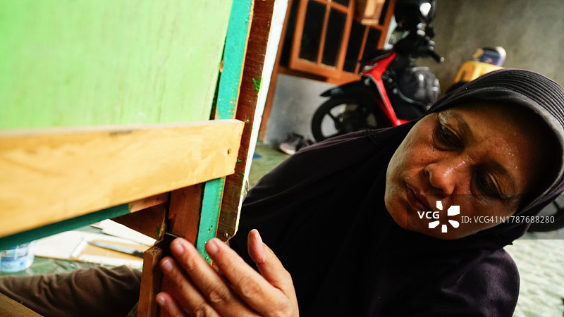 亚洲中年妇女修理家具图片素材