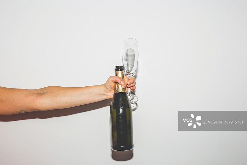 手握香槟酒瓶和酒杯图片素材