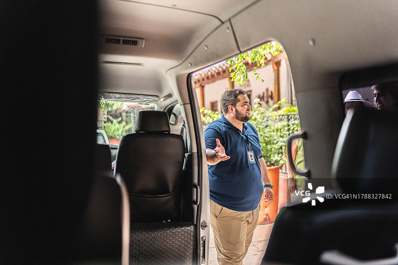 私人导游为游客打开面包车门图片素材