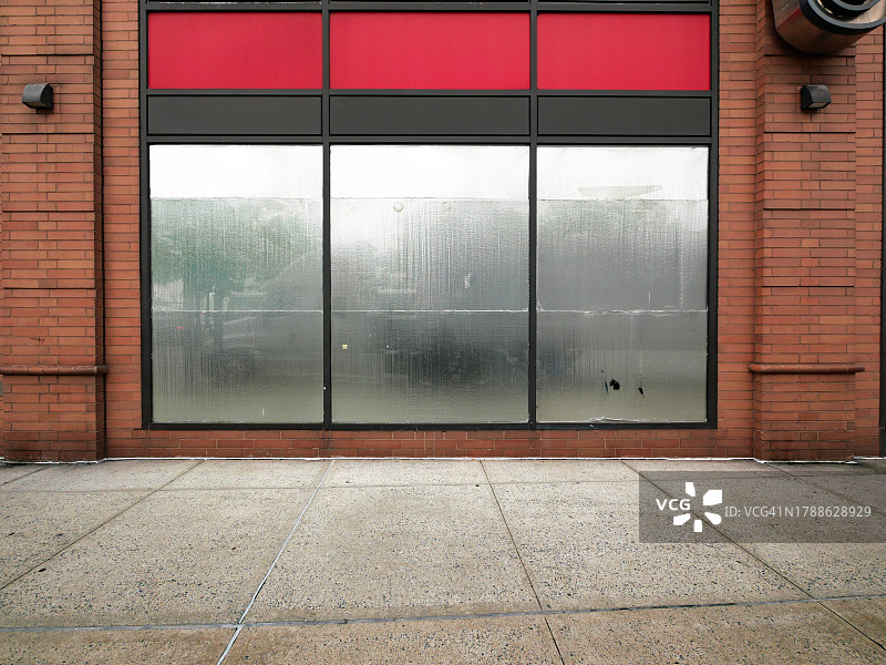 美国纽约市曼哈顿一家倒闭商店的不透明银色窗户和砖墙图片素材