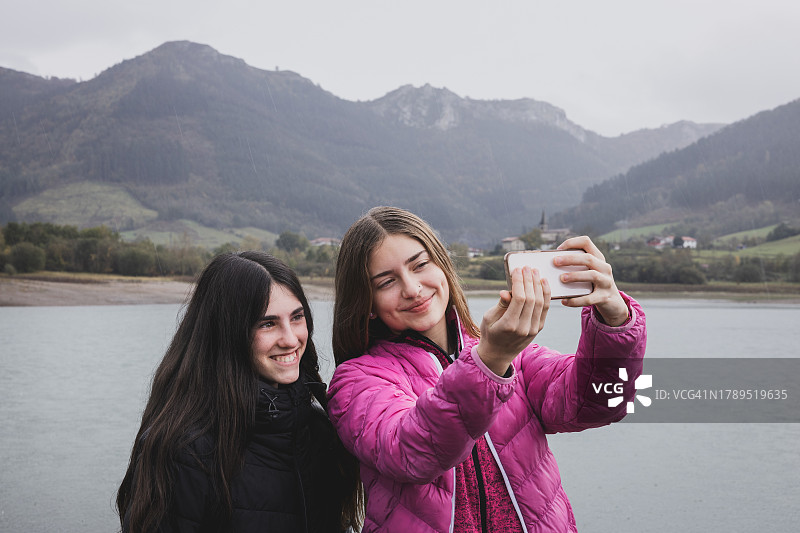 在湖边和山附近自然环境中自拍的少女朋友图片素材