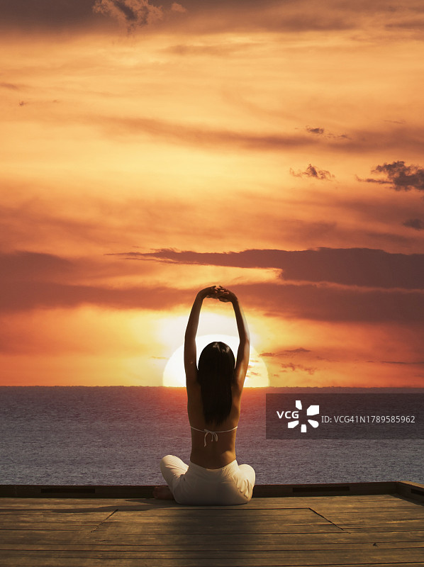 在日落时分练习瑜伽的女人图片素材
