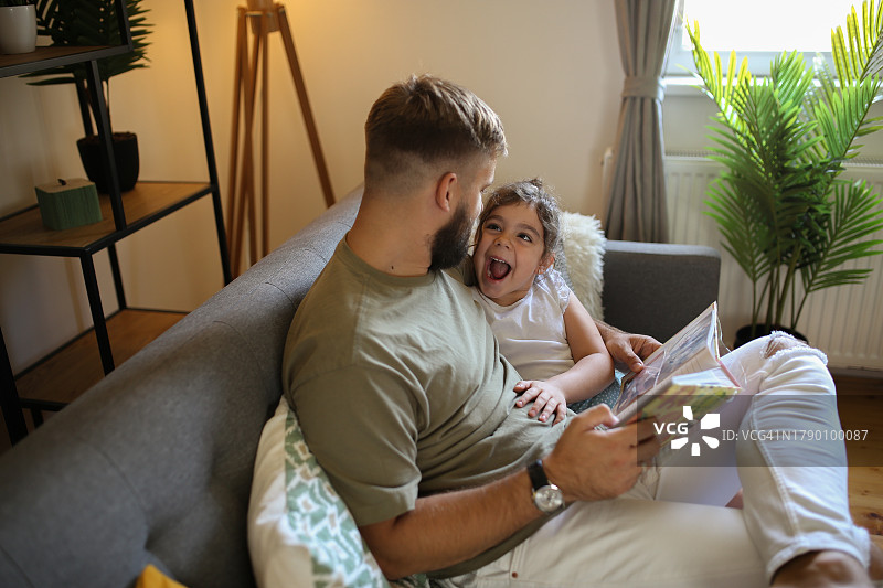 快乐的父女在新家翻看相册图片素材