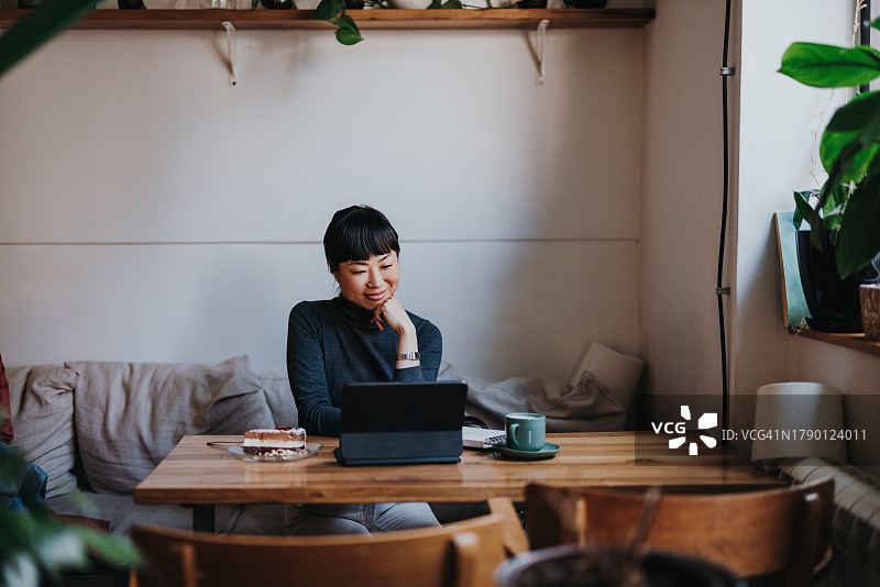 年轻亚洲女性在咖啡馆远程办公的肖像图片素材