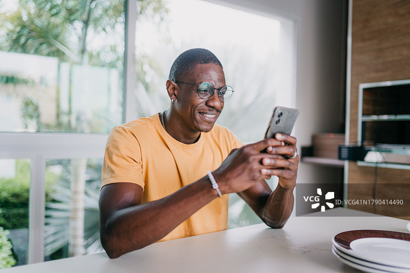 男人在厨房使用智能手机图片素材