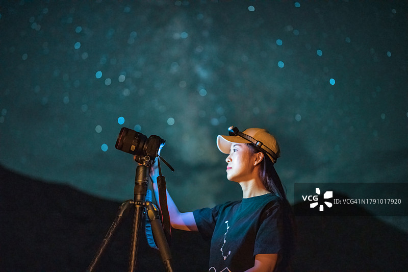 中国女性星空摄影师在星空下拍摄银河图片素材