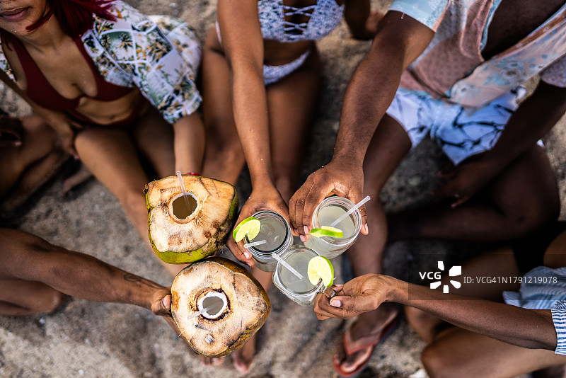 朋友们在海滩上举杯庆祝的高角度视图图片素材