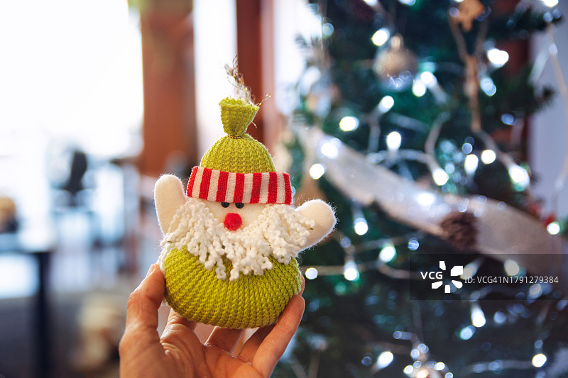 手持圣诞树前的圣诞饰品图片素材