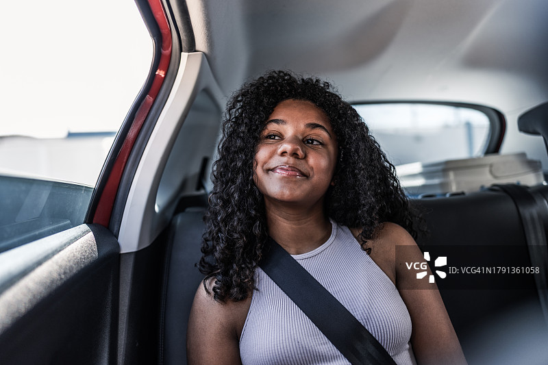 坐在汽车后排座位上看风景的女孩图片素材