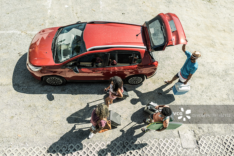 酒店停车场内，俯视角度拍摄的一家人携带行李图片素材