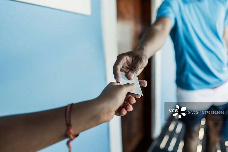 父亲将酒店房间的房卡递给女儿的特写图片素材