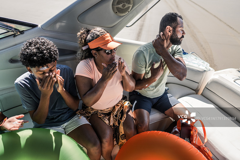 一家人在快艇上涂抹防晒霜图片素材