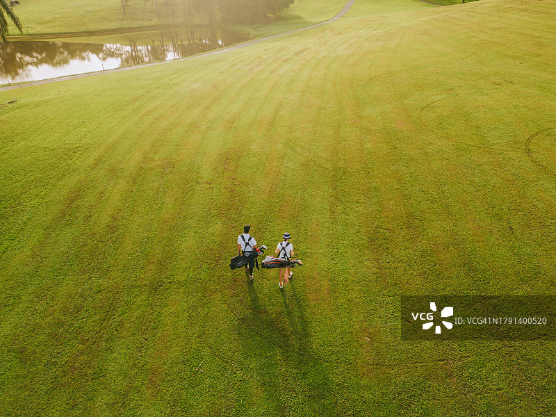 在球道上行走的亚洲高尔夫球手图片素材