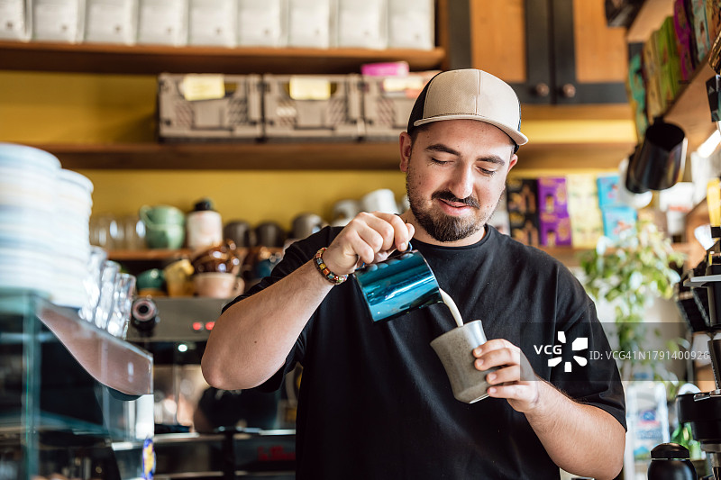 咖啡师在他的咖啡店里准备抹茶拿铁图片素材