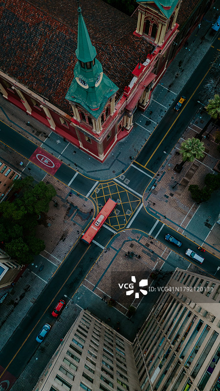 公共汽车和汽车穿过有建筑物的十字路口－竖版照片图片素材