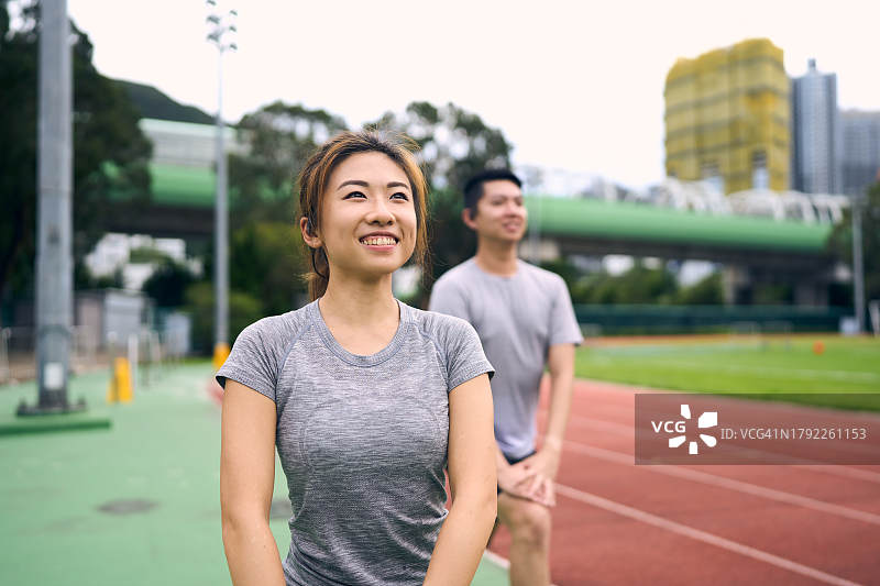 中国夫妇在运动场上做腿部伸展运动图片素材