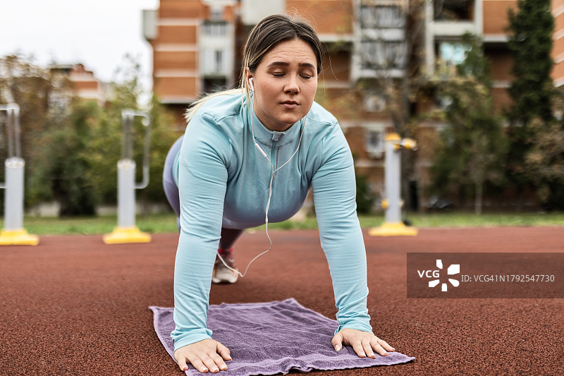 胖乎乎的年轻女人的俯卧撑之旅图片素材