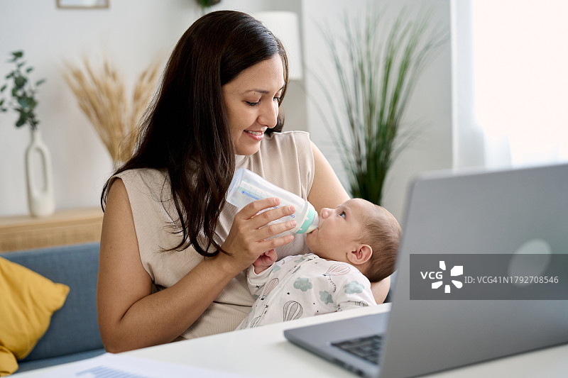 女人在家工作时喂宝宝图片素材