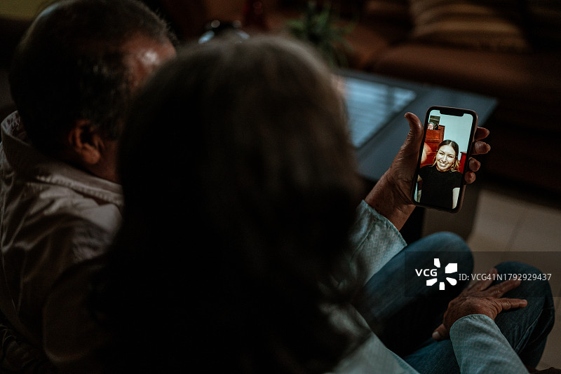 老年夫妇在家用手机与女儿视频通话图片素材