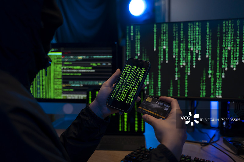 黑客手持信用卡和手机图片素材