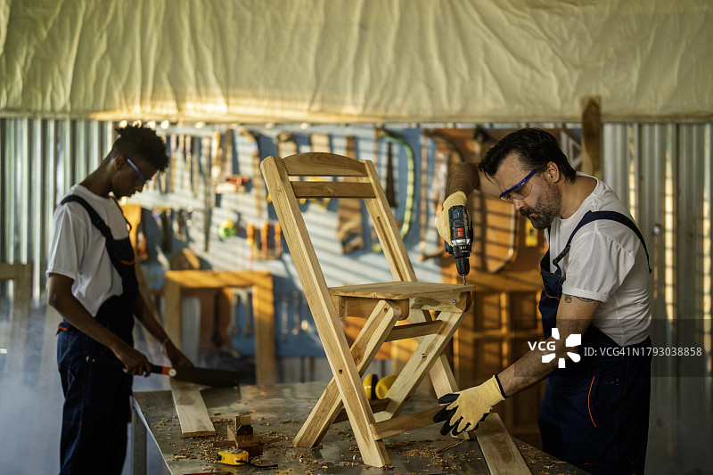 在车间使用钻头的年轻男子图片素材