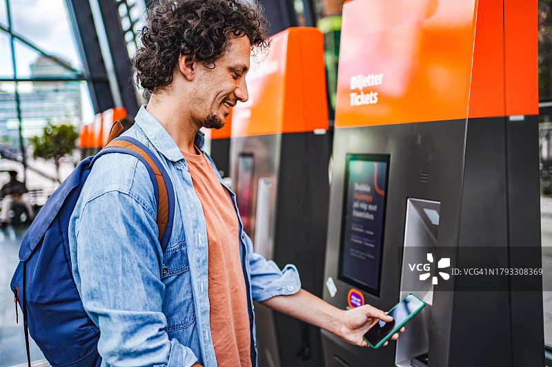 男乘客在车站的自助售票机上购票图片素材