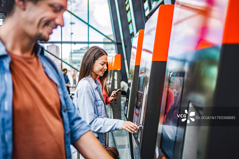 旅行者在车站的自助售票机上购票图片素材