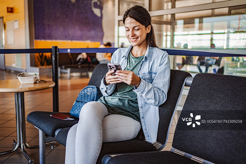 在机场使用手机的女性乘客图片素材
