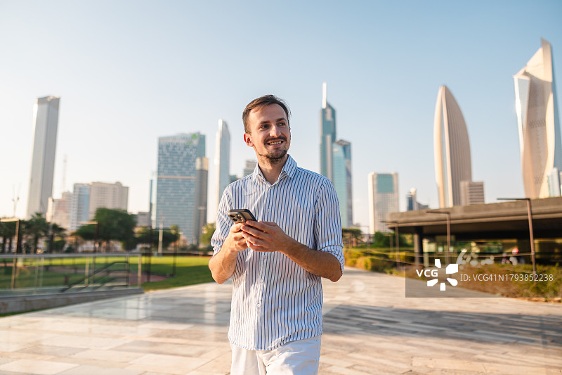 在市中心使用手机的年轻男子图片素材
