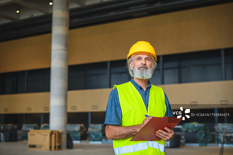 在建筑工地工作的年长的白人项目经理图片素材