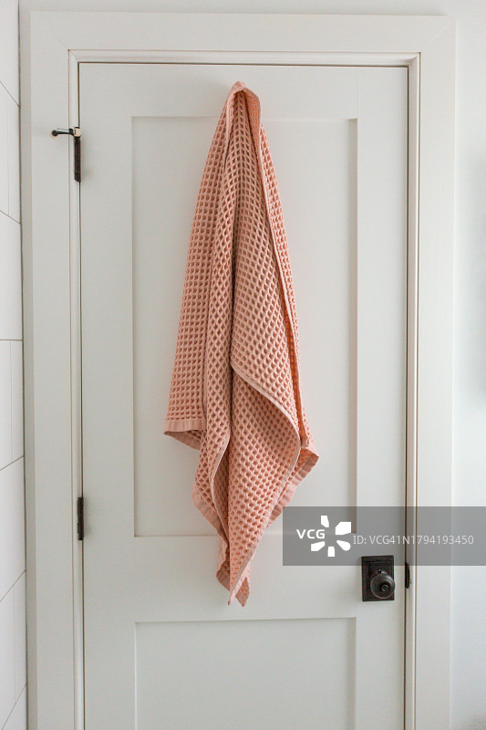 挂在浴室门后的蜂窝织物浴巾图片素材