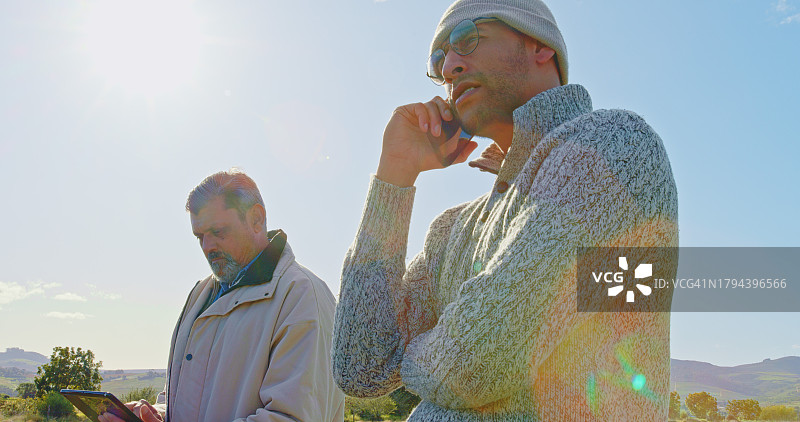 农场：男人通过手机联络，在乡村检查监测情况，进行户外交谈和讨论。农业人员在田野上使用手机、电话和网络，进行农业沟通图片素材