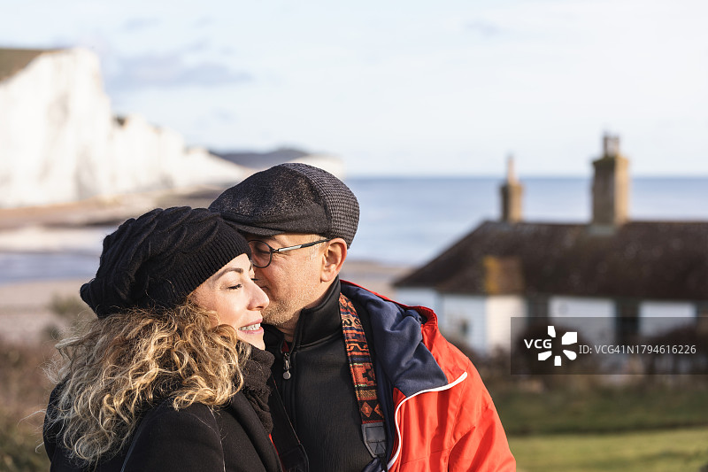 走向英国东萨塞克斯七姐妹海岸救生员小屋的新婚夫妇图片素材