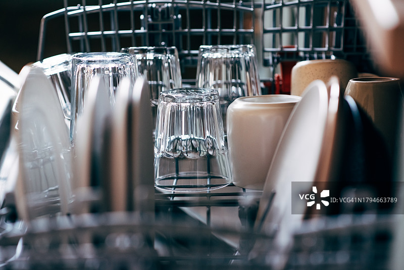 家庭厨房中带有干净餐具的打开的洗碗机图片素材