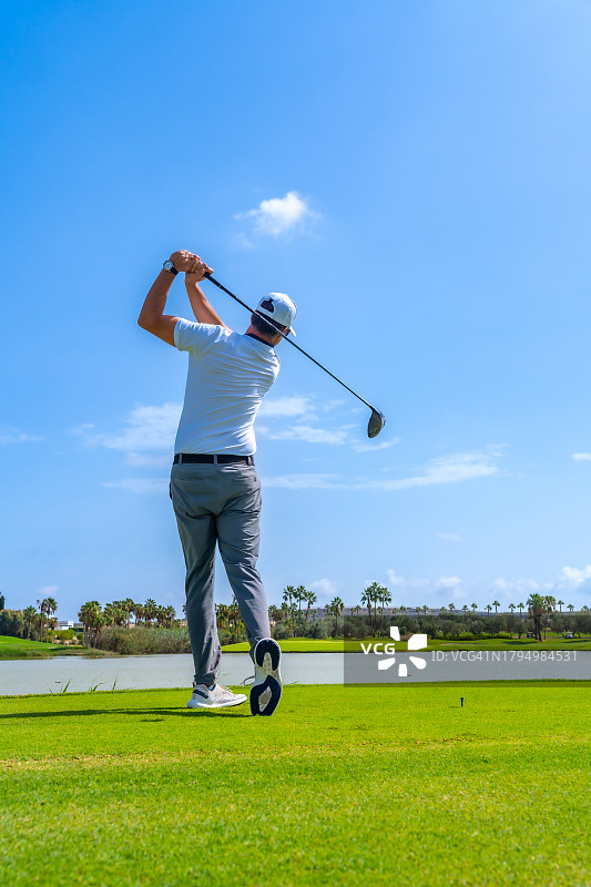 高尔夫球手挥杆击球后的背影图片素材