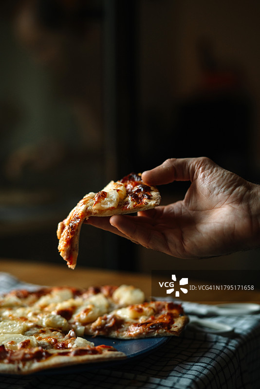 餐桌上，女子手中的披萨图片素材