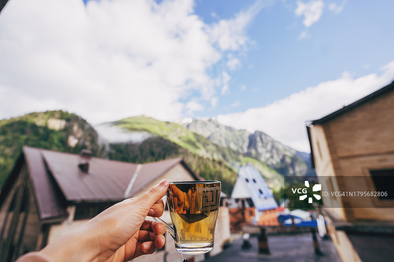 女人在窗台附近端着一杯热饮图片素材