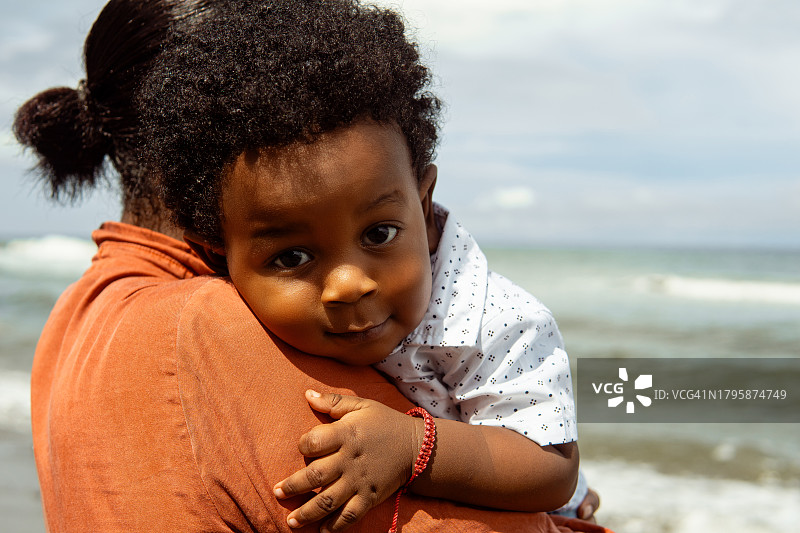 成年女人母亲在海滩抱着新生婴儿图片素材